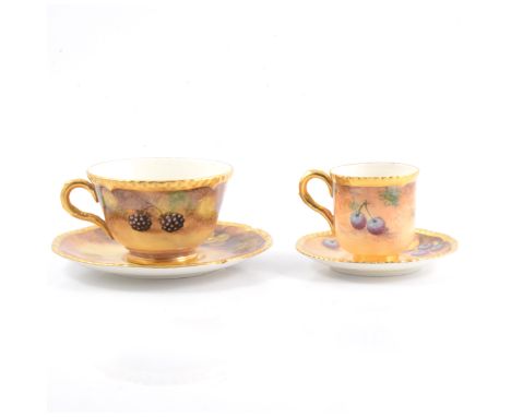 A Royal Worcester cabinet teacup and saucer, painted with fruit, by John Smith; and a coffee can and saucer, signed Roberts.