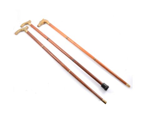 Three walking sticks, a three piece walking stick with a brass horses head handle, a three piece stick with ornate brass hand