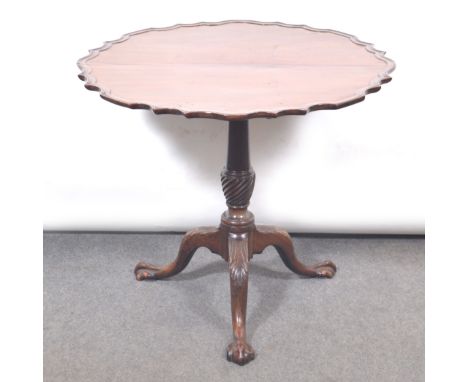 A Georgian mahogany tripod table, tilt-top with shaped and moulded outline, baluster column with spiral twist section, carved