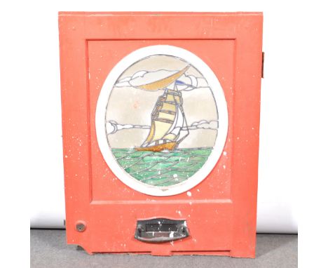 Wooden door panel, oval leaded glass panel of a sailing ship, in the Arts and Crafts style, the glass 53x45cm, the panel 100x