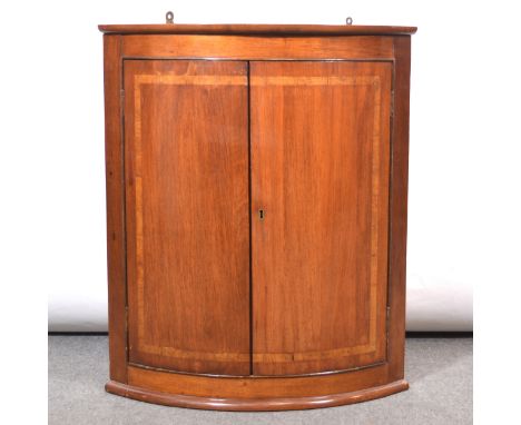 Reproduction mahogany bowfront hanging corner cupboard, fitted with one shelf, width 67cm, depth 47cm, height 80cm.