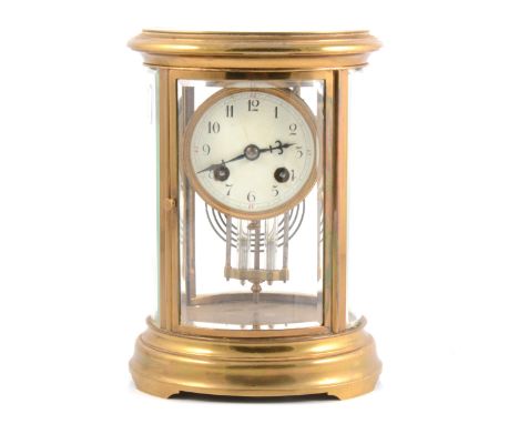Brass oval four glass mantel clock, enamelled dial (chipped) mercury pendulum, the movement striking on a gong, 23cm.