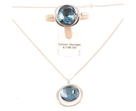 Matching new silver bangle and pendant with a large faux blue topaz, the stones 25mm, the bangle hinged at the front, 60cm fl