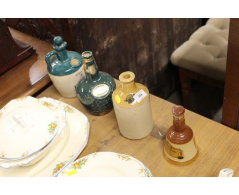 A Bells Scotch Whisky decanter; a stoneware bottle; and two other decanters 