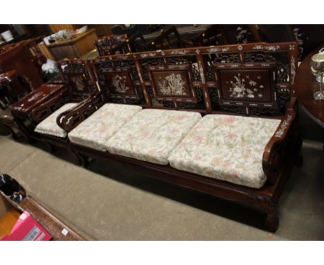 A Chinese hardwood and mother of pearl inlaid three seater settee, with a pair of matching armchairs each with floral and bir