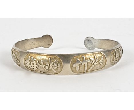 A Chinese silver bangle,  decorated with flowers, bamboo, a horse, and calligraphic symbols, widest point 7cm