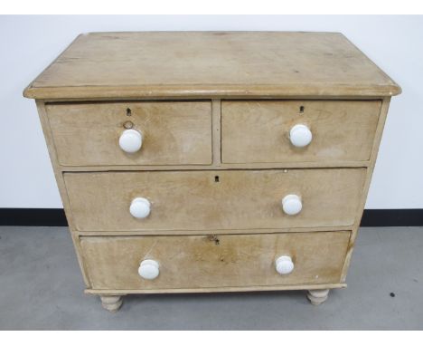 A 19th Century stripped pine chest of drawers, two short drawers over two long drawers, with white ceramic handles, raised on