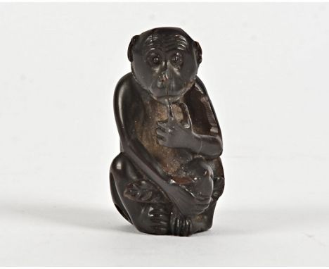 A Japanese boxwood netsuke of a monkey concealing a peach,  with possible artist's mark to base, height 5cm