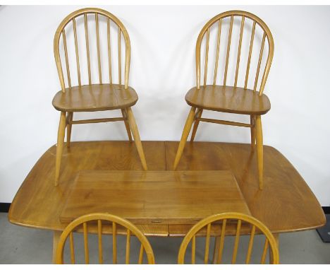 An Ercol blonde extending dining table, 77cm x 150cm, leaf 71cm, height 71cm, with a set of four matching stick back chairs, 