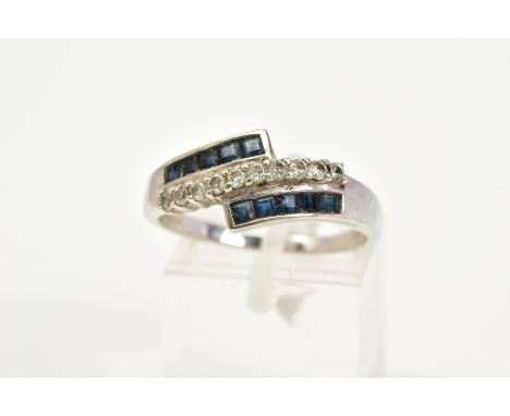 A 9CT WHITE GOLD SAPPHIRE AND DIAMOND RING, of crossover style set with two rows of square cut sapphires with a central row o