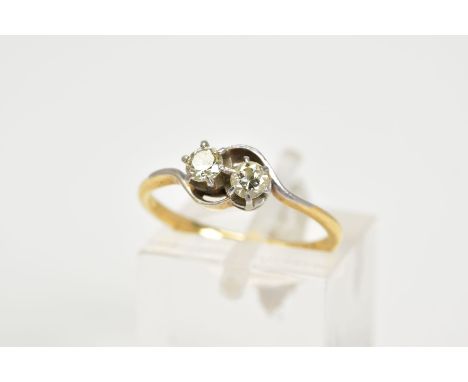A YELLOW METAL DIAMOND RING, of crossover design set with two round brilliant cut diamonds, total estimated diamond weight 0.