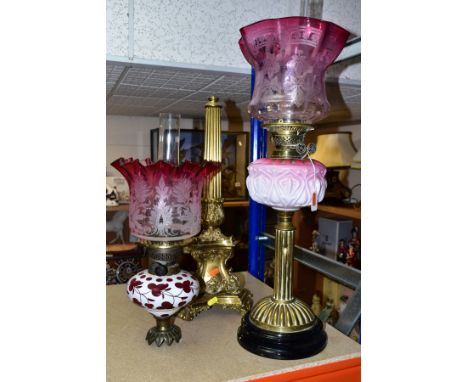A VERITAS OIL LAMP WITH GRADUATED OIL RESERVOIR ABOVE A REEDED COLUMN AND CERAMIC BASE, together with graduated cranberry lam