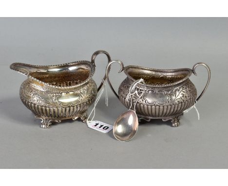 AN EDWARDIAN MATCHED SILVER CREAM JUG, of oval form and sugar bowl gadrooned rim, foliate scroll band above stop reeding on f