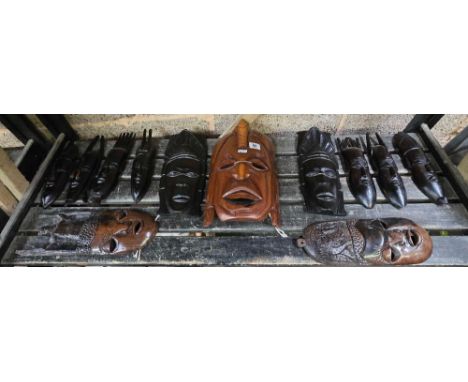 SHELF OF 12 VARIOUS CARVED ETHNIC MASKS