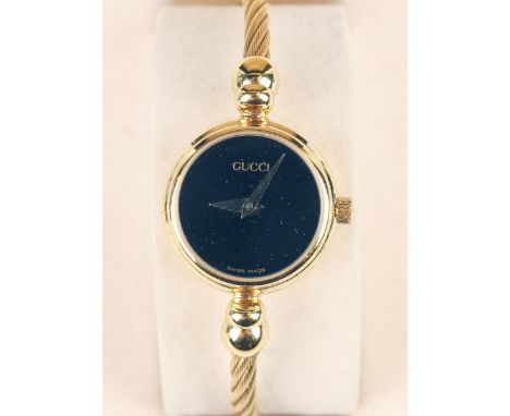 A Gucci gilt metal lady's bangle wristwatch, the signed rectangular dial with gilt hands, the case back detailed 'Gucci 500L'