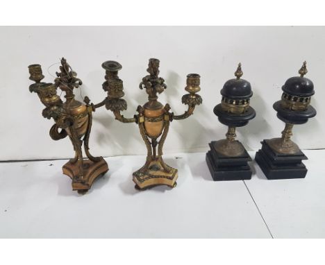 Pair of clock candelabra garniture, beige marble centre and a pair of black slate clock garniture, brass mounted