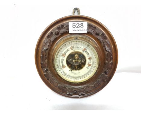 Circular wall barometer in a moulded oak frame, stamped “Mansfield & Sons, Dublin”, 8” dia