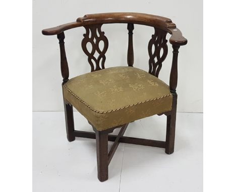 Georgian Mahogany Corner Armchair, having a Chippendale fretwork back, atop a green satin upholstered seat and a cross stretc