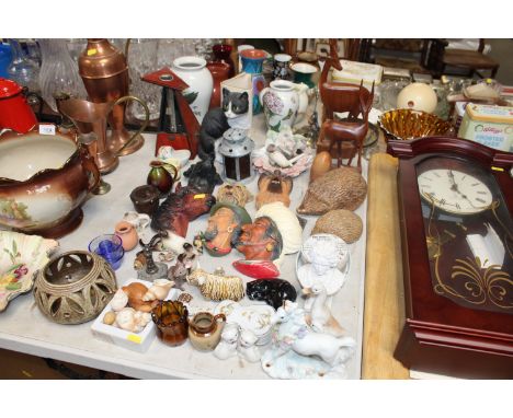 A collection of miscellaneous ornaments to include wall masks, carved wooden animals, a metronome etc. 