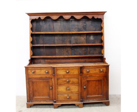 An 18th century North Wales oak dresser, the rack with the moulded cornice above a shaped frieze and three shelves, the base 