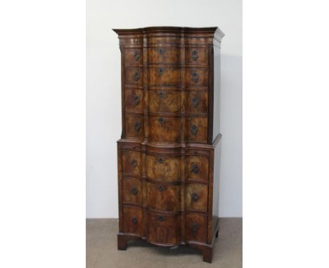 A reproduction walnut chest on chest with a moulded serpentine top above four long graduated drawers, the base with a brushin