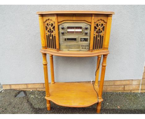 A wooden music stand containing record turntable, tape cassette player, radio and three disc CD unit, approximately 91 cm (h)