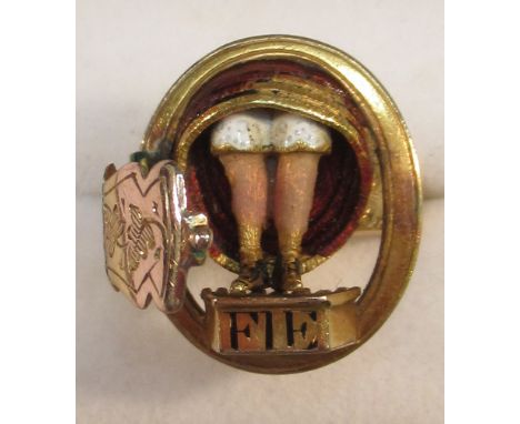 GOLD COLOURED RISQUÉ ENGRAVED AND ENAMELLED RING, THE HINGED TOP OPENING TO REVEAL A PAIR OF WOMAN'S LEGS, ENAMELLED "FIE" BE