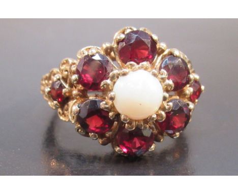 9ct GOLD FLORAL RING SET 8 x 4mm GARNETS ENCLOSING A CIRCULAR 6mm WHITE OPAL, SIZE O½ (6.5g GROSS)