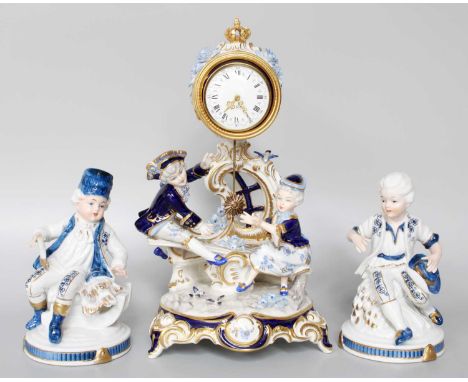 A Porcelain Mantle Timepiece, and a pair of porcelain figuresThe mark is a crowned D. Marked Sandizell. Clock is 31cm high. T