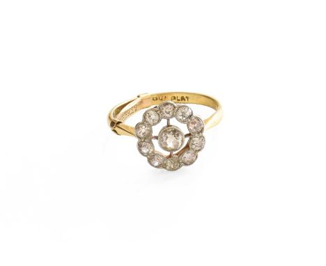 A Diamond Cluster Ring, an old cut diamond within a spaced border of smaller old cut diamonds, in white rubbed over settings,