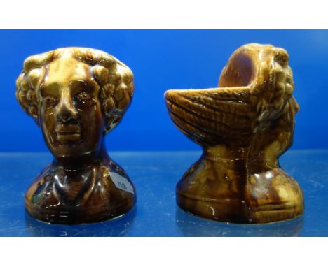 A PAIR OF 19TH CENTURY TREACLE GLAZED POTTERY SASH WINDOW SUPPORTS OR FURNITURE STANDS, in the form of women's heads, each 12