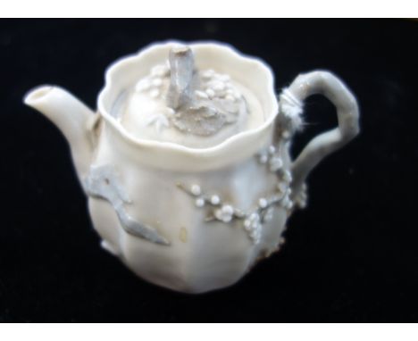 A JAPANESE MINIATURE TEAPOT with relief prunus decoration, the base with an impressed mark, Meiji period 