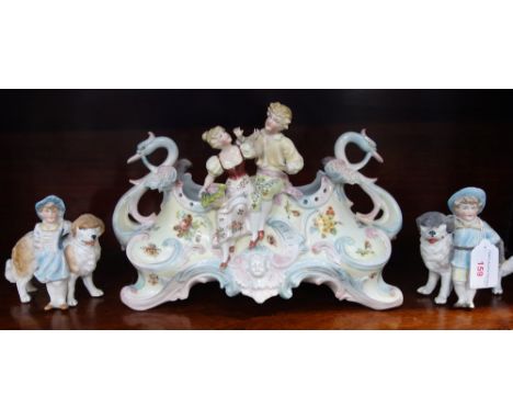 A CONTINENTAL CERAMIC JARDINIERE decorated with two seated figures and a pair of bisque figures with dogs