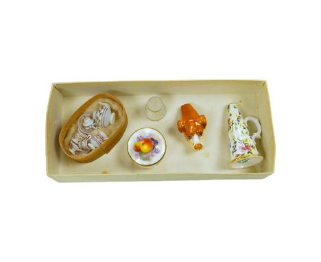 A mixed collection of miniature items including a Royal Worcester hound’s head whistle, a candle extinguisher and a glass tea