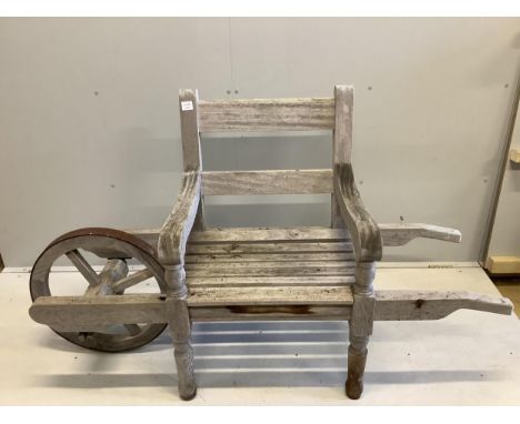 An Andrew Crace weathered teak wheel barrow garden bench. width 166cm, depth 58cm, height 96cm. Condition - fair to good Not 