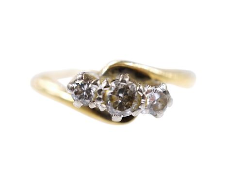 A modern `18ct gold and three stone diamond set crossover ring, size O, gross weight 3.4 grams. Condition - fair