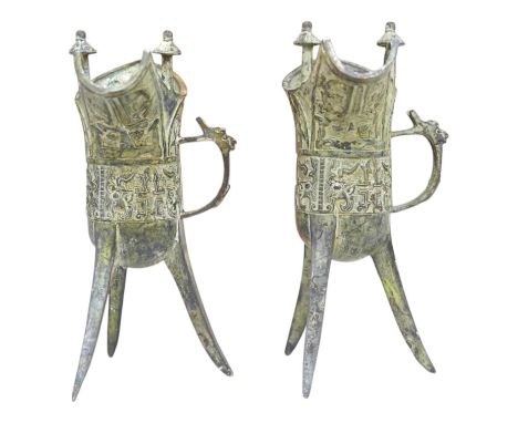 A pair of Chinese archaistic bronze vessels on tripod legs, jue, 20.5cm high. Condition - fair.
