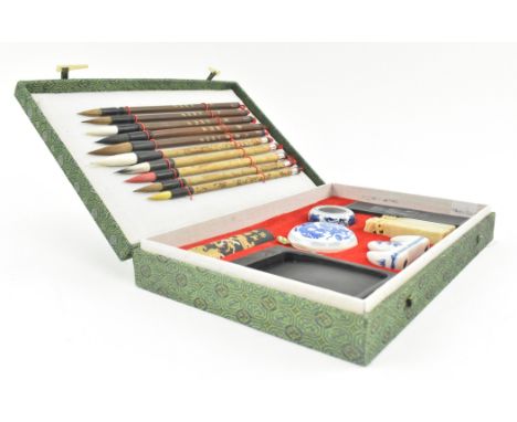 A Chinese calligraphy writing set. The set to include ten writing brushes, an inkwell, one ink stick decorated with dragon, o