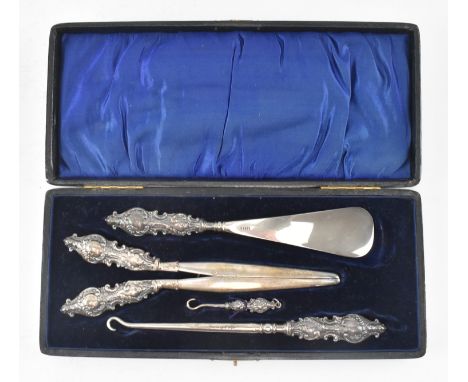 An early 20th century dressing set. The set to include a stainless steel shoehorn, a German silver glove stretcher and a butt