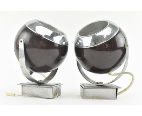 A pair of mid century Space Age 1970s wall lamp light sconces of eyeball form. Each cased in burgundy painted chrome. Sold as