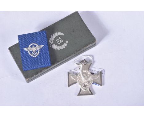 A GERMAN THIRD REICH POLICE 18 YEAR LONG SERVICE CROSS, the award comes in a green/grey hinged box and with its blue ribbon c