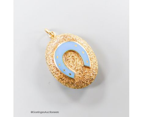   A Victorian style textured yellow metal and enamel set oval pendant, with horseshoe motif and glazed back, 23mm, gross weig