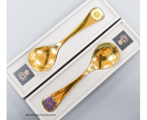   Two boxed Georg Jensen gilt sterling and enamel year spoons, 1973 &amp; 1974 (Corn Marigold and Corn Cockle), 15cm, gross 9