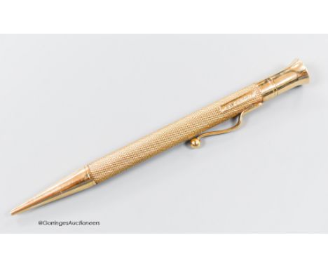   A late 1940's engine turned 9ct gold cased pencil, with engraved initials, 12.1cm.