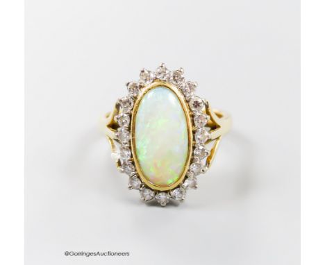   An 18ct, white opal and diamond set oval cluster ring, size N, gross 6.2 grams.