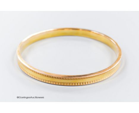   A 1930's engine turned 9ct gold bangle, interior diameter 73mm, 9 grams.
