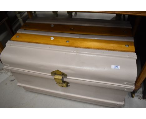 An early 20th century painted metal trunk, with later wood