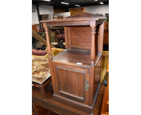 An early 20th century mahogany pot cupboard having shelf top with turned supports and cupboard under, w 40cm