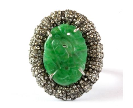 A white metal (tested minimum 9ct gold) ring set with carved jade and diamonds, (M.5).