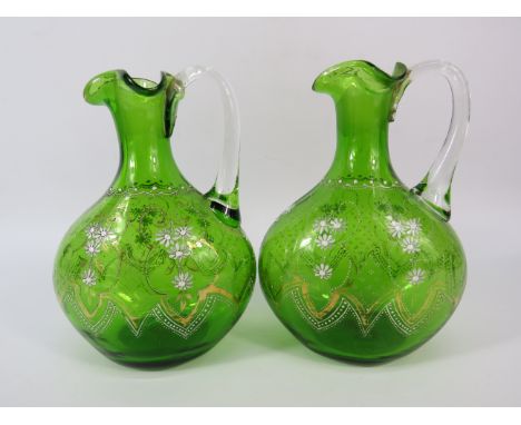 Pair of Antique Bohemian green glass jugs with enamel painted decoration, 7" tall.